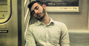 man sleeping on a subway train (flickr by david shankbone)