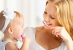 Mom brushes teeth with daughter