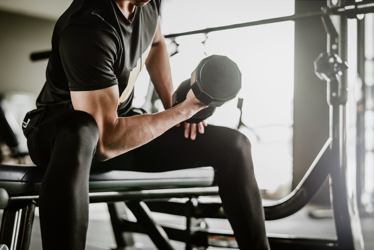 DOMS. reddit share. cropped shot of fitness man doing concentration curls e...